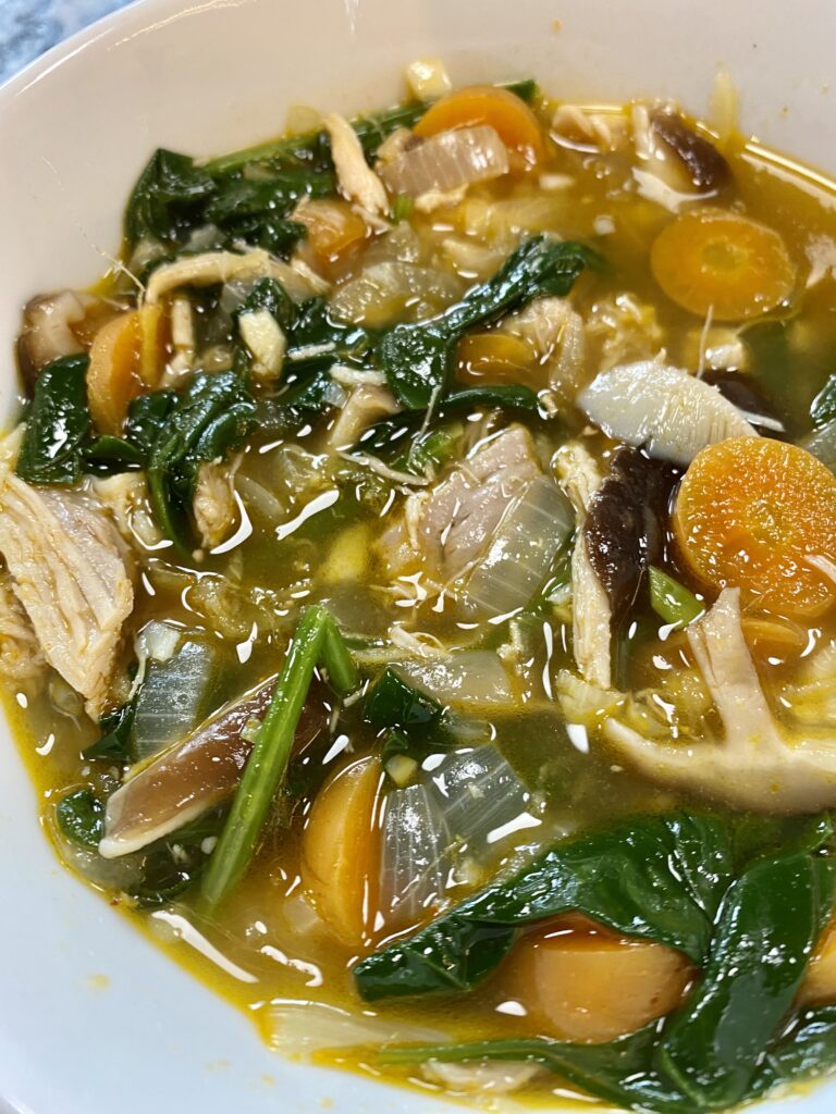 chicken soup with spinach, shiitake mushrooms, garlic, ginger, spinach, carrot, onion, and spices